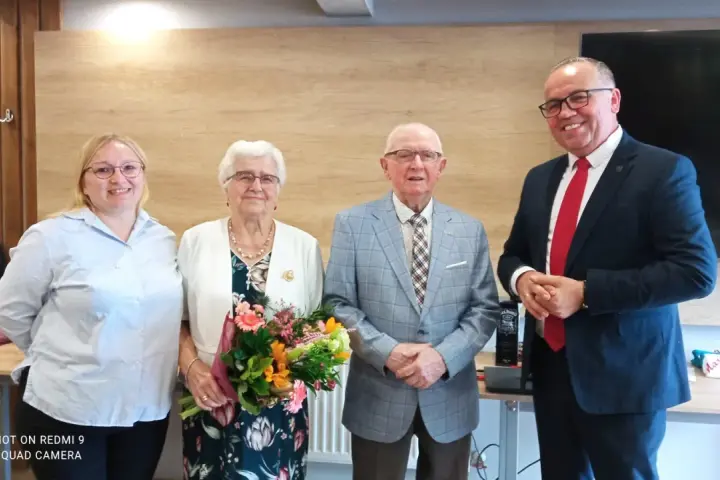 Para świętuje 36 rocznicę ślubu. Uśmiechnięci jubilaci z bukietem kwiatów, towarzyszą im młodsze osoby.