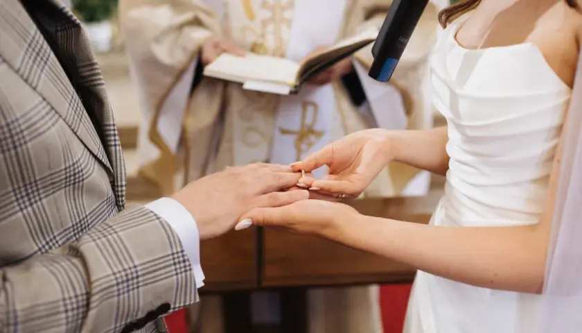 Panna Młoda zakłada obrączkę na palec Pana Młodego. Ceremonia ślub jednostronny w kościele.