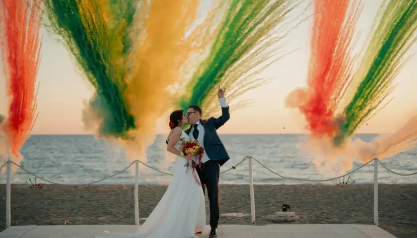 Para młoda całująca się na tle kolorowych fajerwerków na plaży.