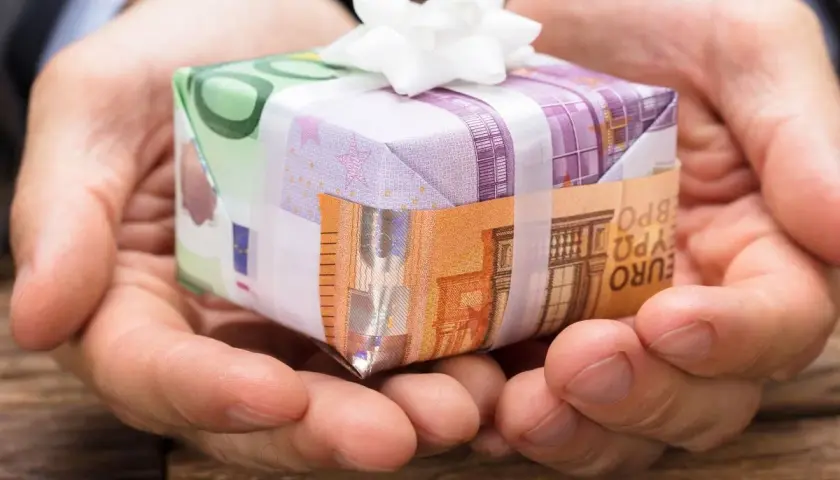 Oto jak śmiesznie zapakować pieniądze na prezent: banknoty euro tworzą małe pudełko przewiązane białą wstążką.